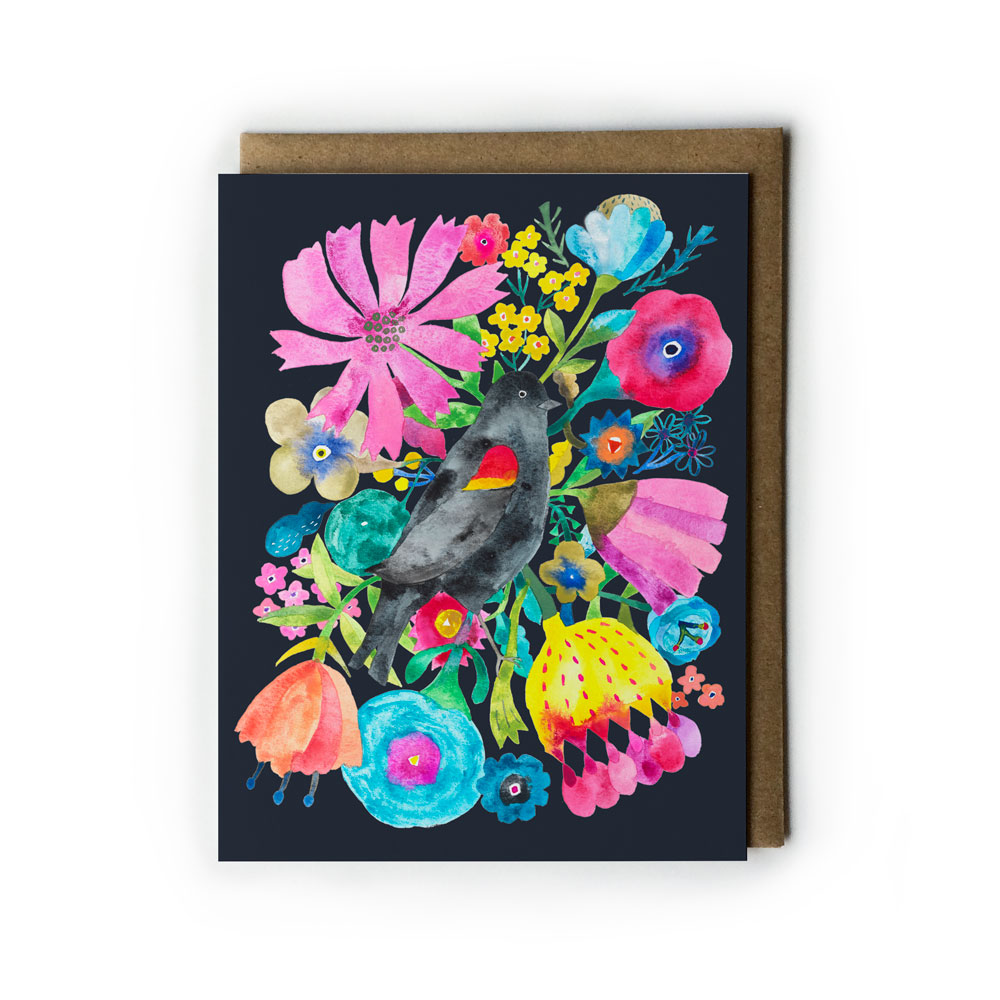 Vibrant watercolor greeting card featuring a blackbird surrounded by colorful flowers and foliage on a dark background, with a kraft envelope