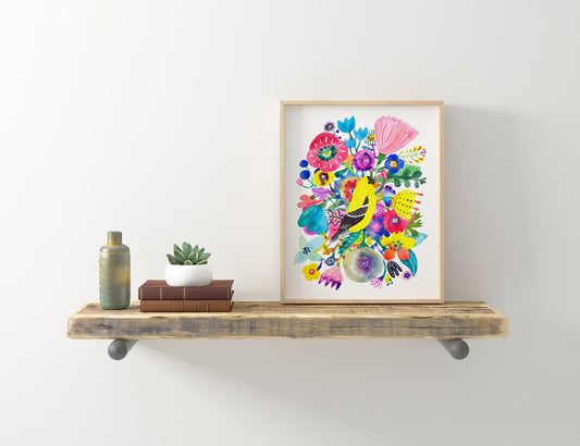 Vibrant giclee art print of goldfinch and colorful flowers in wooden frame displayed on rustic floating shelf with decorative items, showcasing bright watercolor style artwork against white wall
