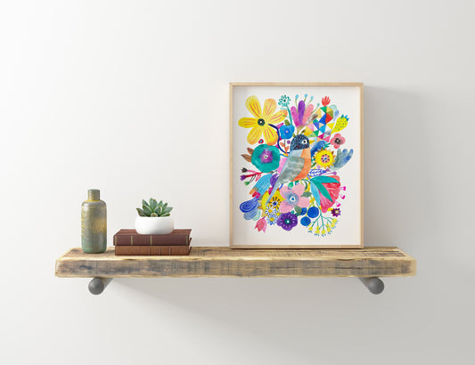 Colorful giclee art print featuring a whimsical robin surrounded by vibrant flowers, displayed in a wooden frame on a rustic floating shelf with books, plant, and vase