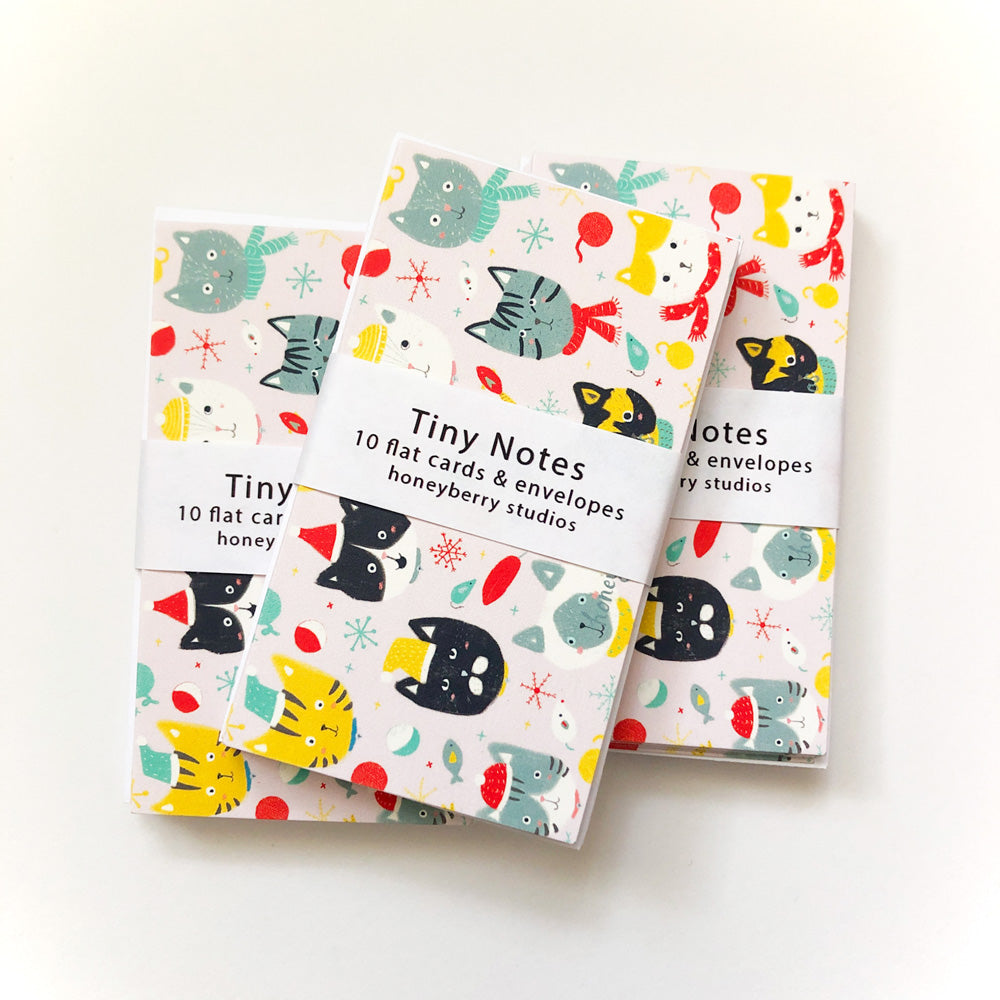 Colorful winter-themed tiny note cards featuring cute cat designs, snowflakes, and festive patterns, bundled together with a wrap-around band. Perfect for mini greetings and gift enclosures.