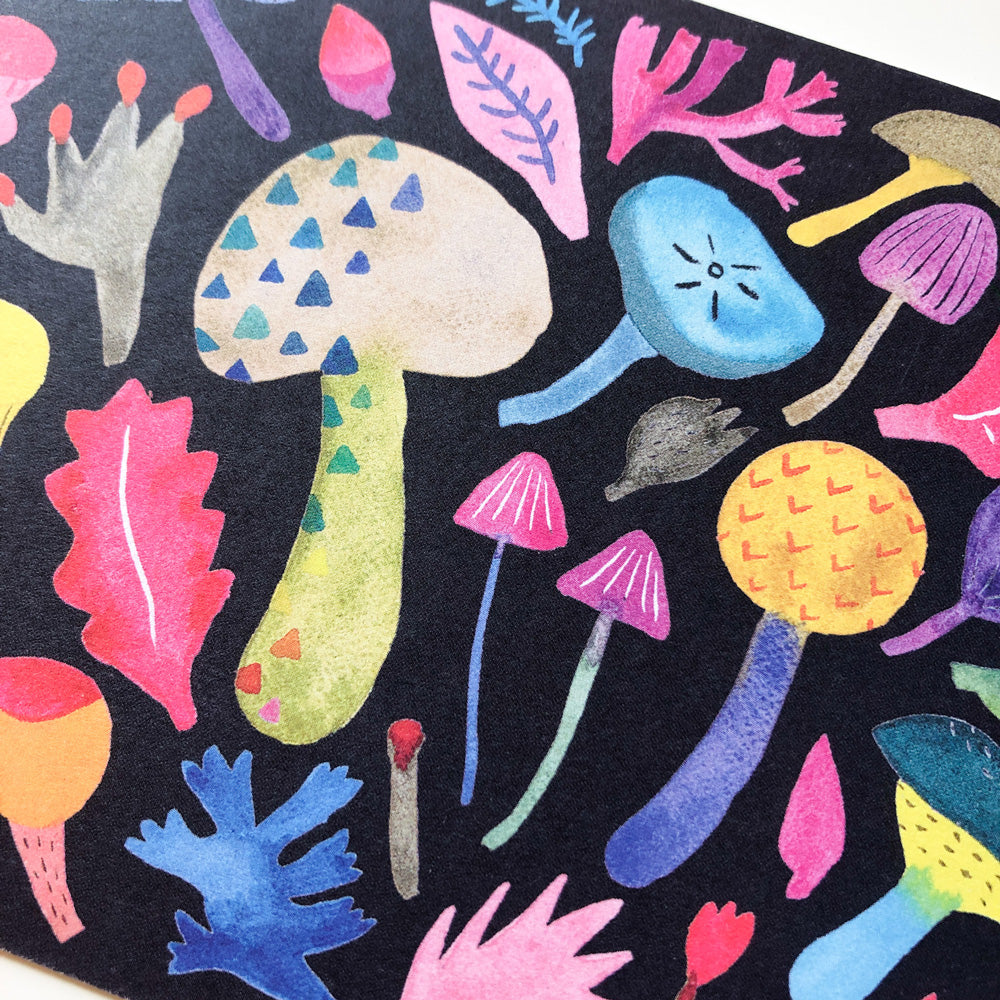 Colorful watercolor illustration of whimsical mushrooms and leaves on a black background, featuring various shapes and sizes in vibrant hues of pink, blue, yellow, and purple, creating a playful and artistic design for a greeting card