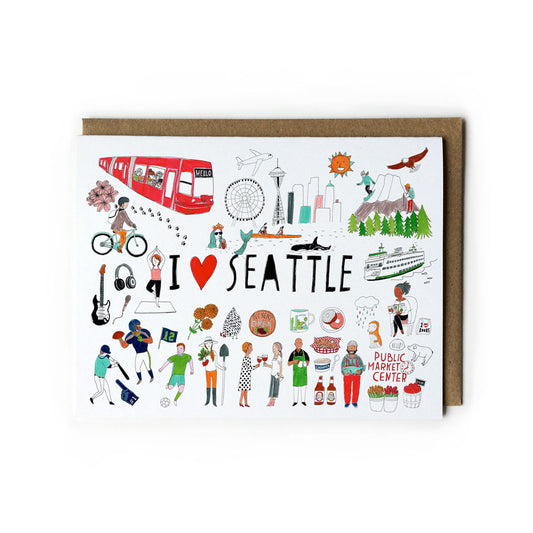 Illustrated greeting card featuring iconic Seattle landmarks, activities, and culture including Space Needle, monorail, cyclists, musicians, coffee, seafood, and Pike Place Market, with "I heart Seattle" text and kraft envelope