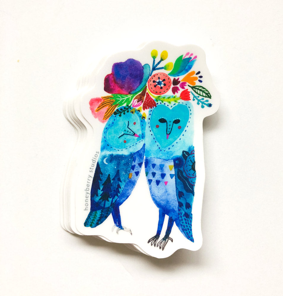Colorful vinyl sticker featuring two whimsical blue barn owls with floral decorations, perfect for nature lovers and owl enthusiasts