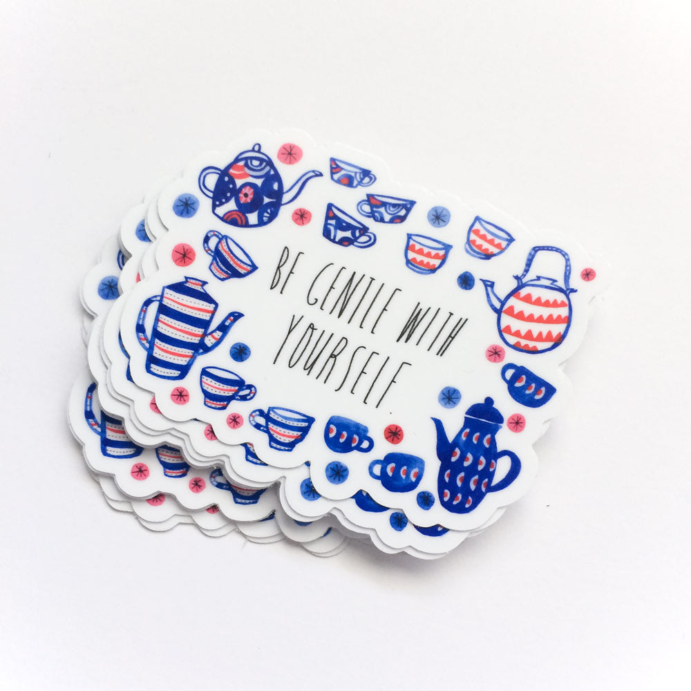 Vinyl sticker with "Be Gentle with Yourself" text surrounded by blue and red tea set illustrations, including teapots, cups, and floral designs on a scalloped white background