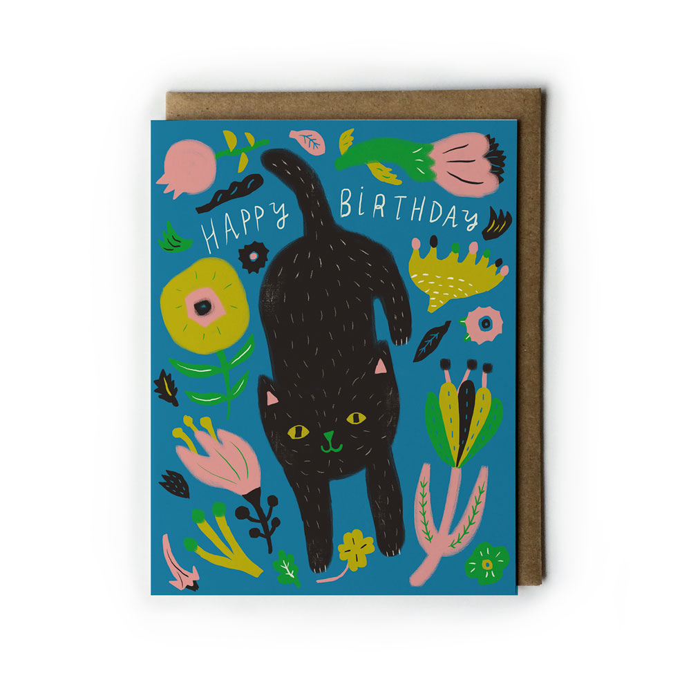 Colorful birthday card featuring a black cat surrounded by whimsical flowers and plants on a vibrant blue background, with "Happy Birthday" text, paired with a kraft paper envelope