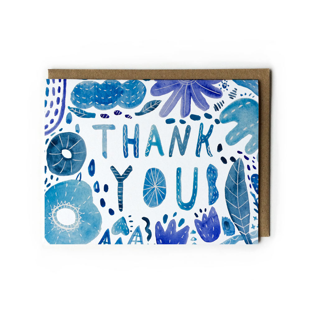 Handmade blue watercolor thank you card with floral and leaf designs, featuring "THANK YOU" text in the center, accompanied by a kraft paper envelope