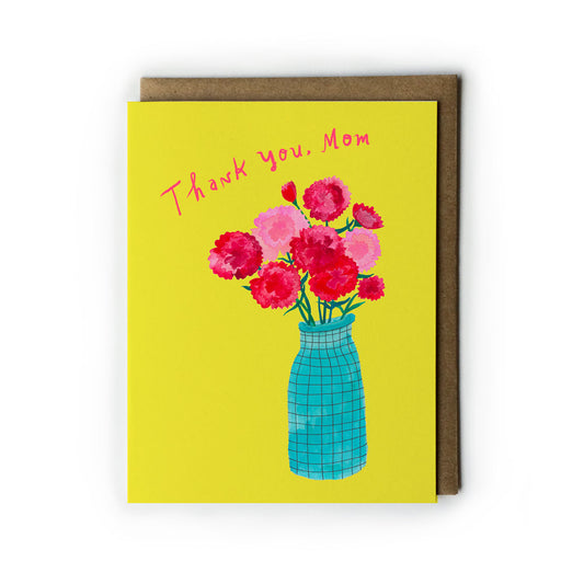 Vibrant yellow Mother's Day card featuring colorful carnations in a blue vase, with "Thank you, Mom" handwritten text, accompanied by a kraft paper envelope