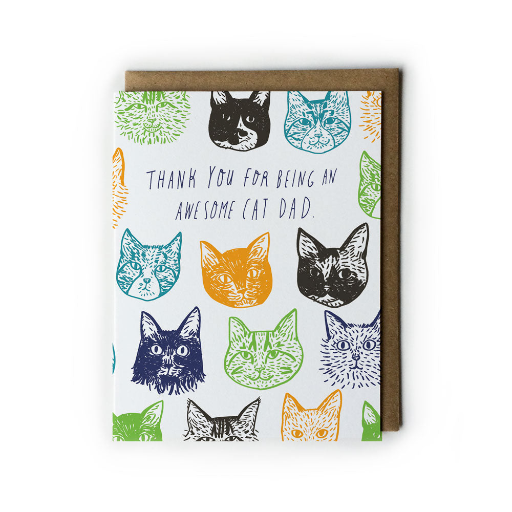 Father's Day card featuring colorful cat face illustrations surrounding the message "Thank you for being an awesome cat dad" on white background with brown envelope
