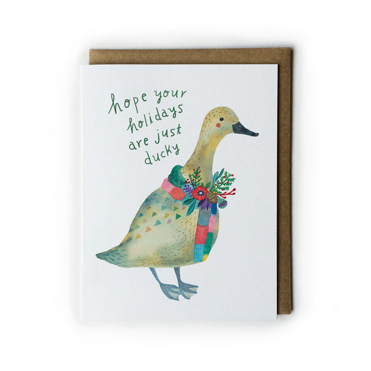 Watercolor holiday card featuring a cheerful yellow duck wearing a colorful festive scarf, with handwritten text "hope your holidays are just ducky" on white background, paired with kraft paper envelope