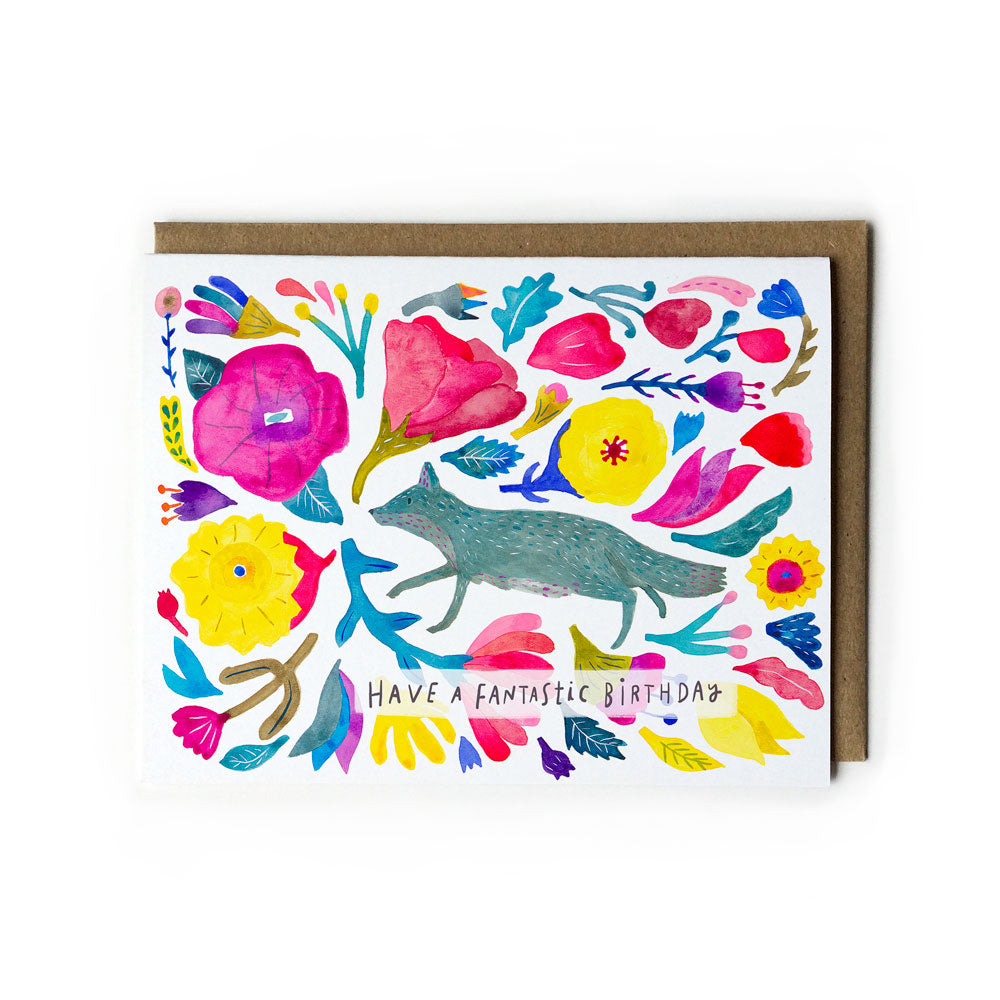 Colorful watercolor birthday card featuring a whimsical fox surrounded by vibrant flowers and foliage, with "Have a fantastic birthday" message, accompanied by kraft paper envelope