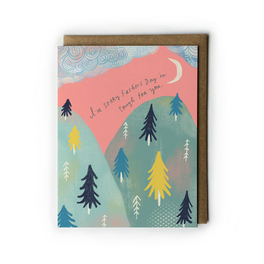 Empathy card with colorful mountain landscape, trees, and crescent moon. Handwritten text reads "I'm sorry Father's Day is tough for you." Kraft paper envelope included.