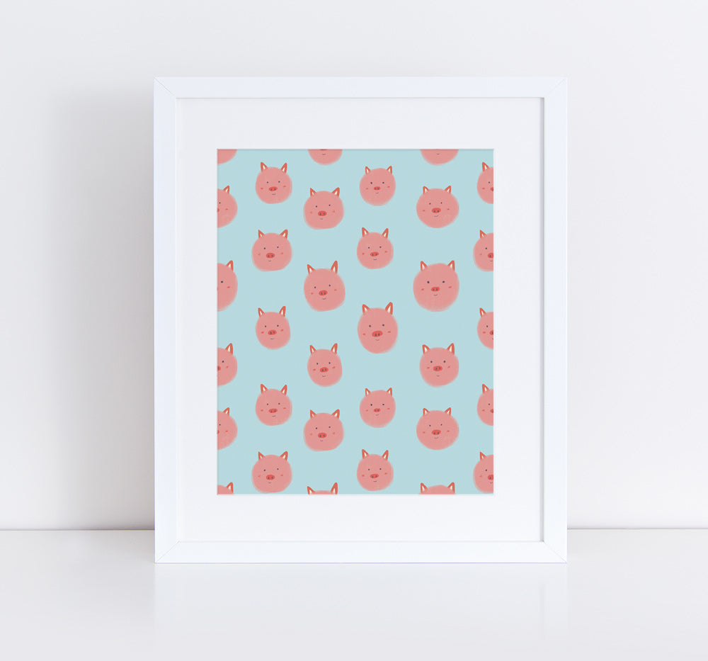Framed art print featuring a repeating pattern of cute pink pig faces on a light blue background, titled "Little Piggies". The playful design showcases smiling cartoon pig heads arranged in rows, creating a cheerful and whimsical effect suitable for home decor.