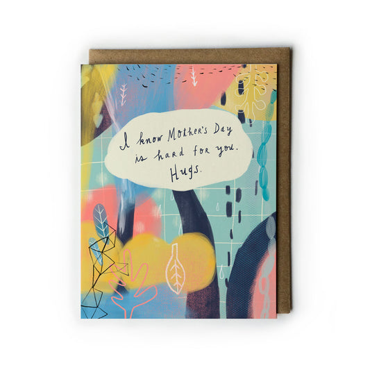 Empathetic Mother's Day card with abstract art featuring pastel colors and handwritten message "I know Mother's Day is hard for you. Hugs." on a white speech bubble, paired with kraft paper envelope.