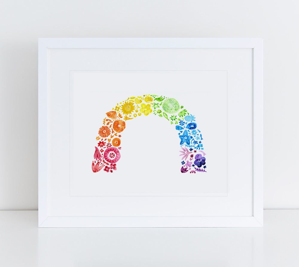 Colorful watercolor floral arch in rainbow gradient, featuring various flower shapes and sizes, displayed as a giclee art print in white frame against light background