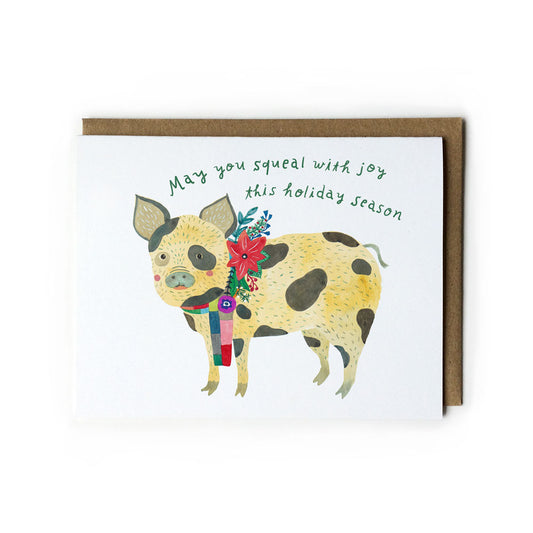 Watercolor holiday greeting card featuring a cheerful spotted pig wearing a colorful scarf with text "May you squeal with joy this holiday season" and a matching kraft paper envelope