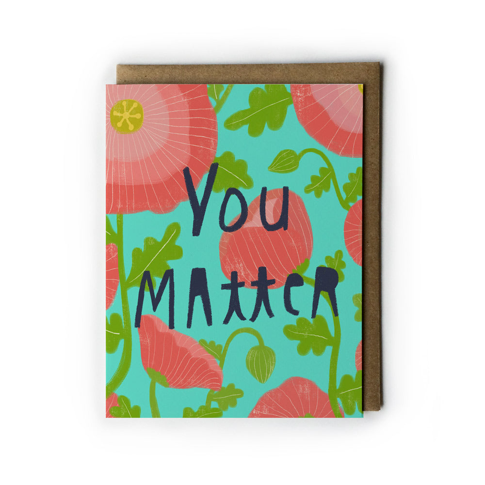 Colorful greeting card with "You Matter" text surrounded by pink poppies and green leaves on teal background, with kraft paper envelope