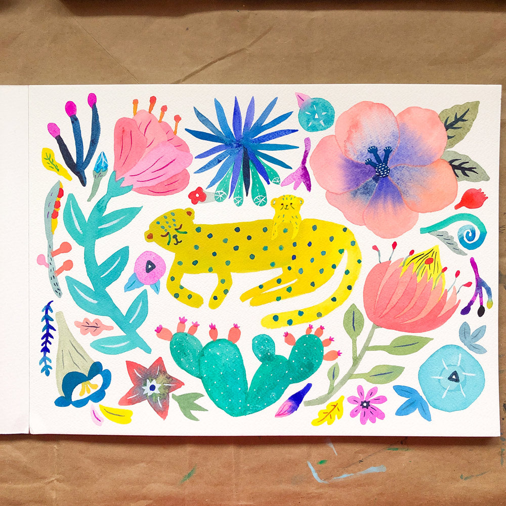 Colorful watercolor greeting card featuring a stylized cheetah surrounded by vibrant flowers, cacti, and abstract floral elements on white paper, displayed on kraft paper background