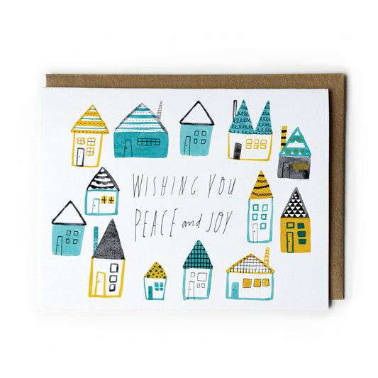 Whimsical watercolor holiday card featuring colorful folk houses with handwritten message "Wishing You Peace and Joy" in teal and yellow color scheme, paired with kraft paper envelope
