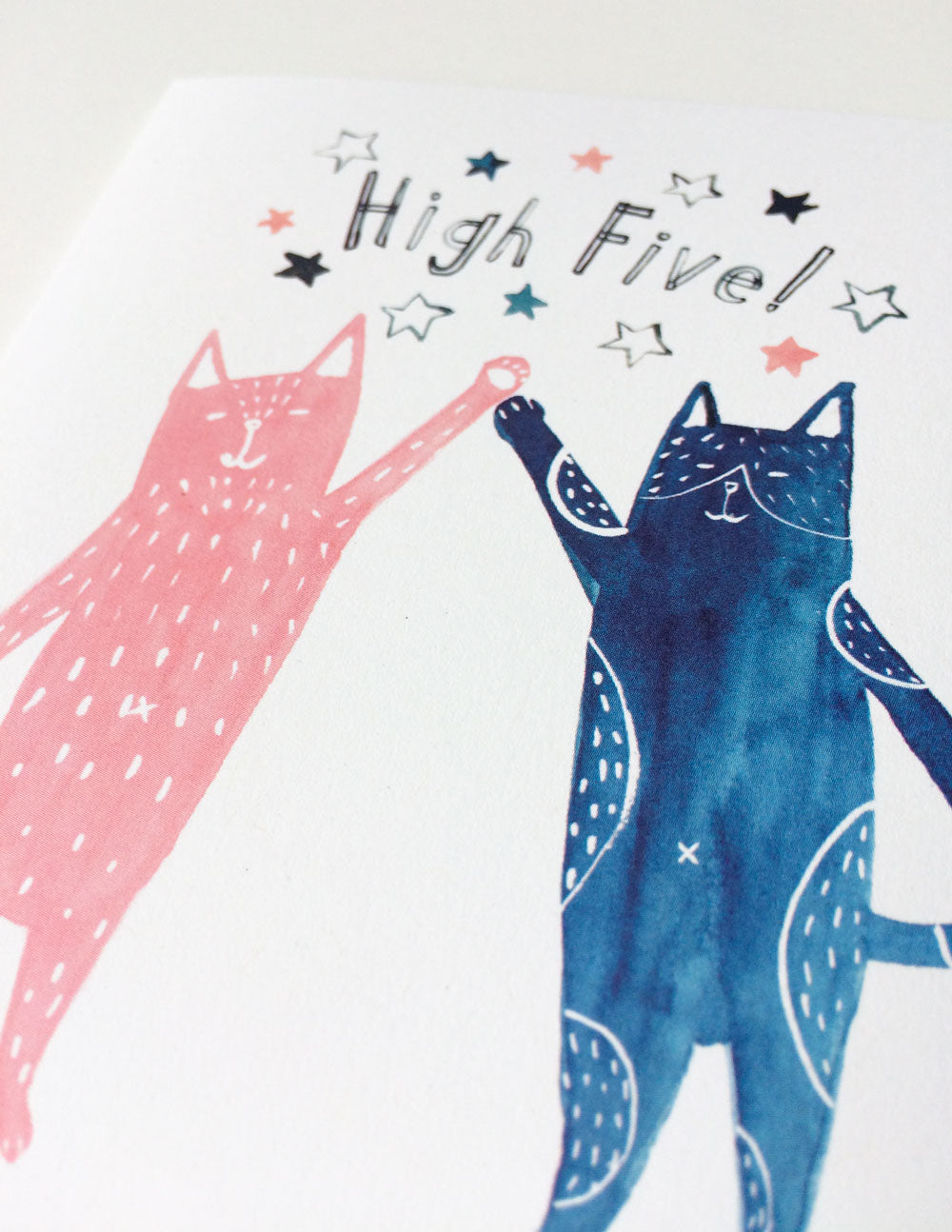 Watercolor illustration of two playful cats, one pink and one navy blue, giving a high five with 'High Five!' text and colorful stars, perfect for celebration greeting card