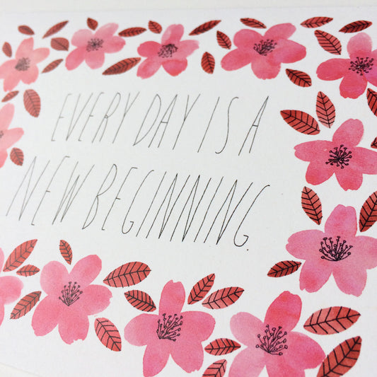 Handwritten text "Every day is a new beginning" surrounded by watercolor pink flowers and red leaves, creating a delicate and inspirational greeting card design