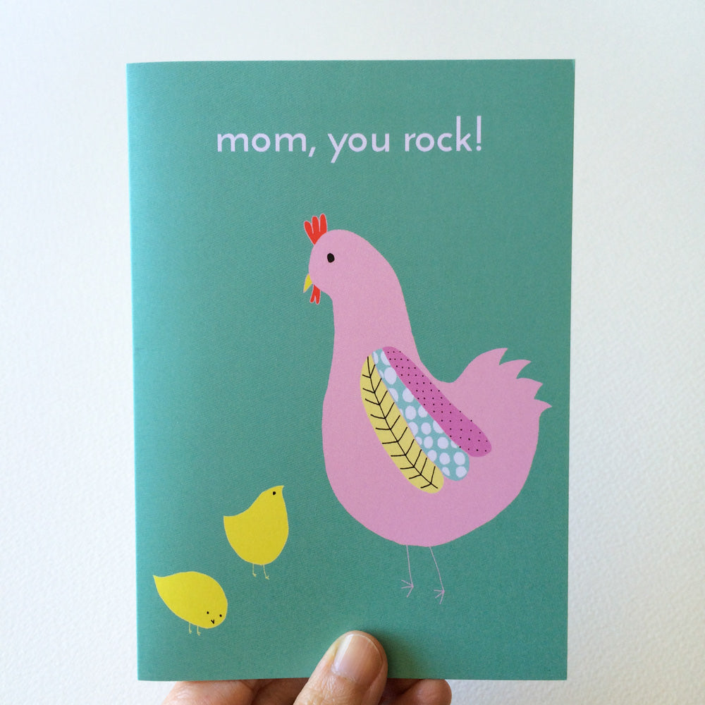 Mother's Day card featuring a colorful illustration of a pink hen with decorative feathers and two yellow chicks on a teal background, with the text "mom, you rock!" Perfect for chicken-loving moms or mother figures.