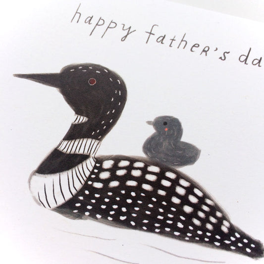 Father's Day card featuring hand-drawn illustration of adult loon with baby loon chick on its back, swimming on water. Text reads "happy father's day" in handwritten style.