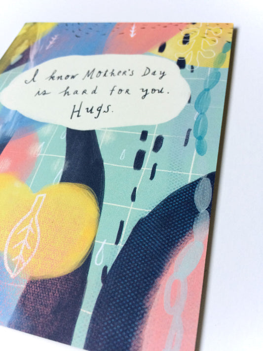 Mother's Day empathy card with abstract pastel artwork and handwritten message "I know Mother's Day is hard for you. Hugs." on a colorful background featuring yellow, blue, and pink shapes.
