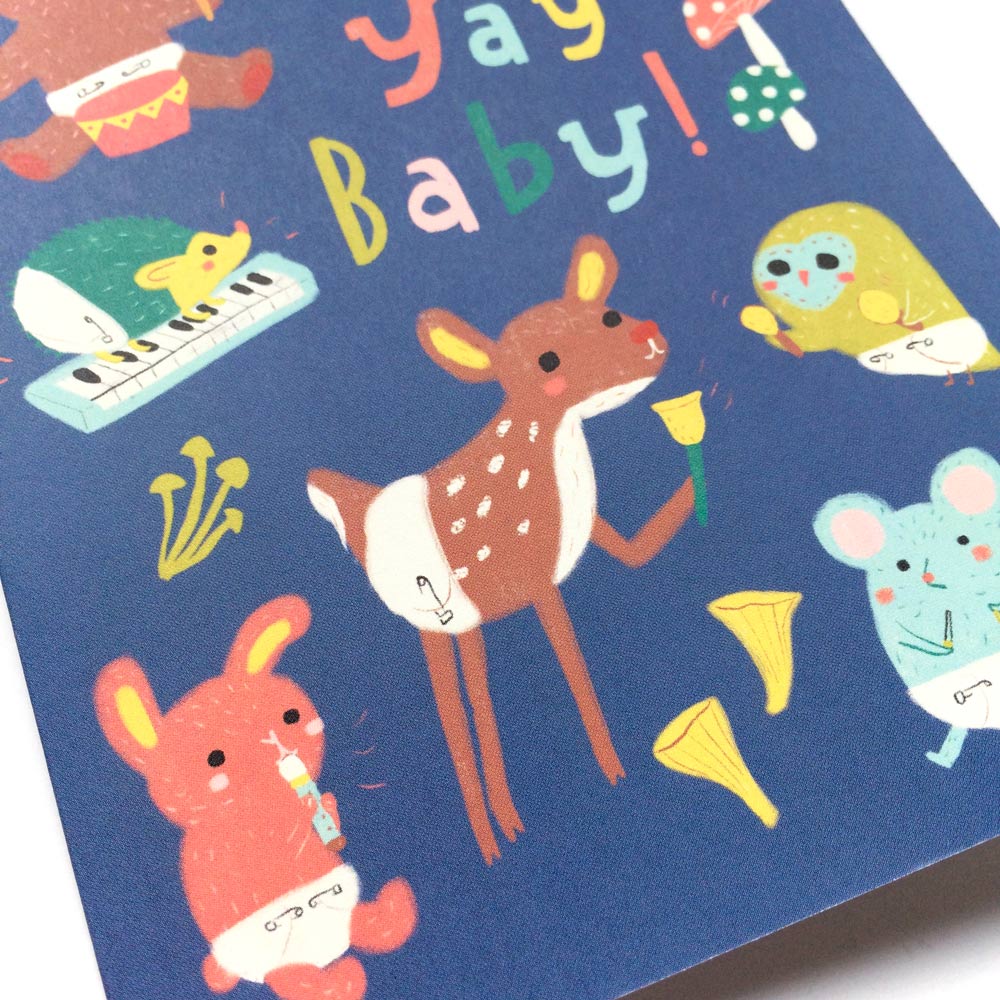 Cute baby woodland animals in diapers playing musical instruments on a navy blue greeting card with colorful "Yay Baby!" text, perfect for baby showers