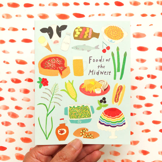 Colorful illustrated notecard featuring various Midwest foods and ingredients, including corn, cheese, fish, hot dog, and Jell-O, with text "Foods of the Midwest" held against a background with red dot pattern