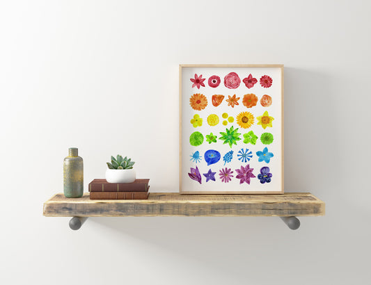 Colorful watercolor flower chart print in rainbow order displayed on wooden shelf with decorative items, showcasing vibrant floral designs in various shapes and styles