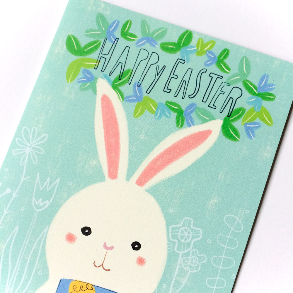 Easter Bunny Mug Greeting Card featuring a cute white bunny with long ears, rosy cheeks, and a blue bow tie, surrounded by colorful leaves and flowers on a mint green background with "Happy Easter" text