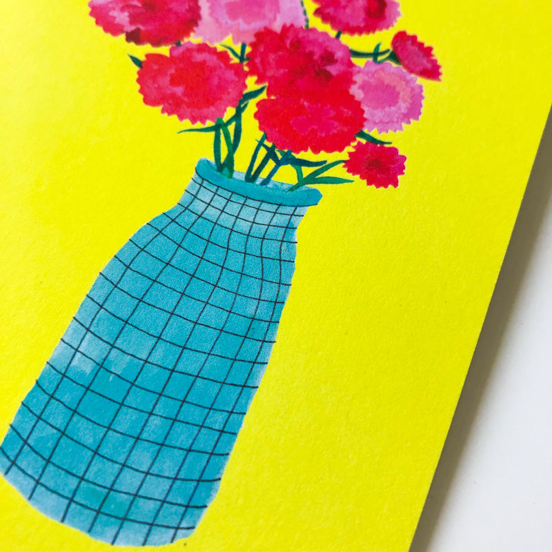 Vibrant Mother's Day card featuring pink carnations in a blue checkered vase against a bright yellow background, perfect for expressing love and appreciation on a special day