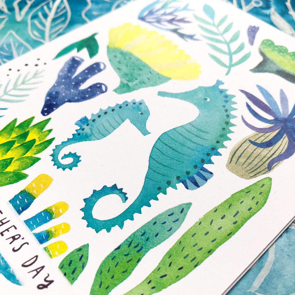 Watercolor greeting card featuring vibrant seahorses, colorful sea plants, and marine elements on white background with 'Happy Day' text, perfect for Father's Day or ocean-themed occasions