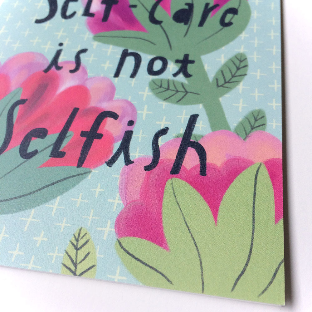Greeting card with floral design and handwritten text "Self-care is not selfish" in pink and green tones on light blue background with white stars, perfect for encouraging self-care and emotional well-being