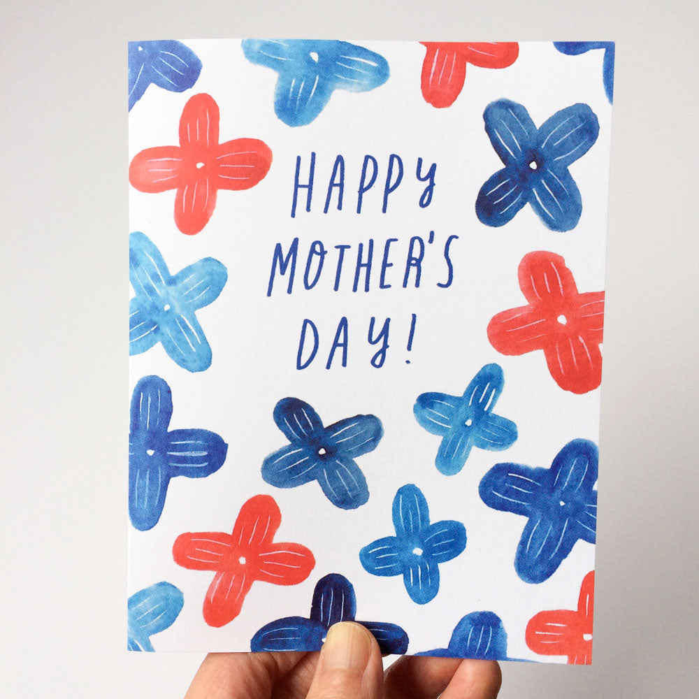 Blue Lilac Mother's Day Card with colorful floral design featuring red and blue watercolor flowers surrounding text "Happy Mother's Day!" Hand holding card to showcase size and texture of recycled white card stock.