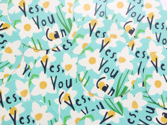 Colorful floral pattern featuring white daisies and green leaves with repeating text "Yes, You Can" in black handwriting on a light blue background, creating a cheerful and motivational design for a vinyl sticker