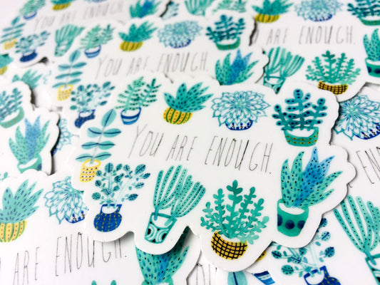 Colorful vinyl stickers featuring various succulent plant designs and the inspirational phrase "You Are Enough" repeated throughout, arranged in a scattered pattern on a white background.