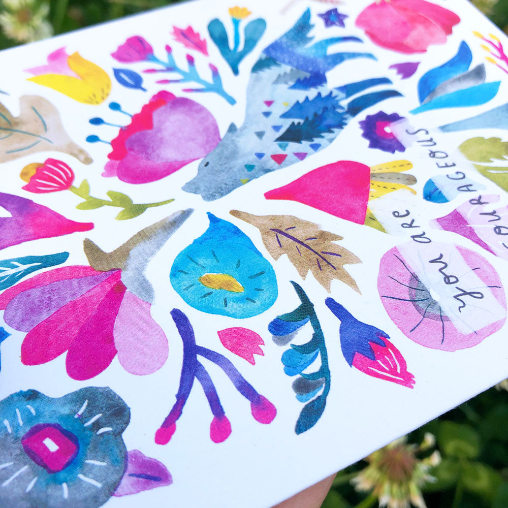 Vibrant watercolor greeting card featuring colorful floral and nature-inspired elements, including a coyote silhouette, flowers, leaves, and abstract shapes in bright pink, blue, purple, and yellow hues on white background