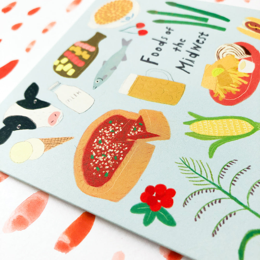 Colorful illustrated notecard featuring various Midwest foods including corn, cheese, fish, and casserole, with "Foods of the Midwest" text in the center, on a light blue background