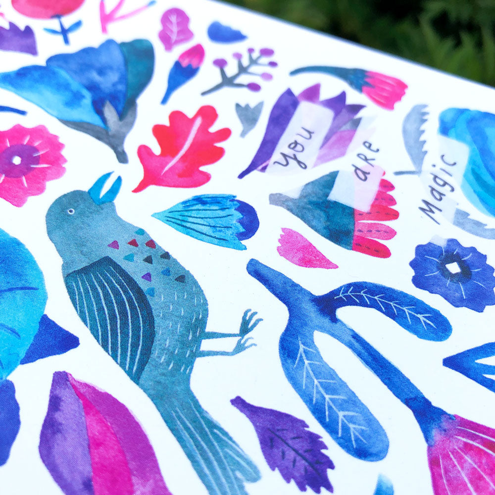 Colorful watercolor greeting card design featuring a blue raven, flowers, leaves, and the words "You are magic" in vibrant pink and purple hues on white background