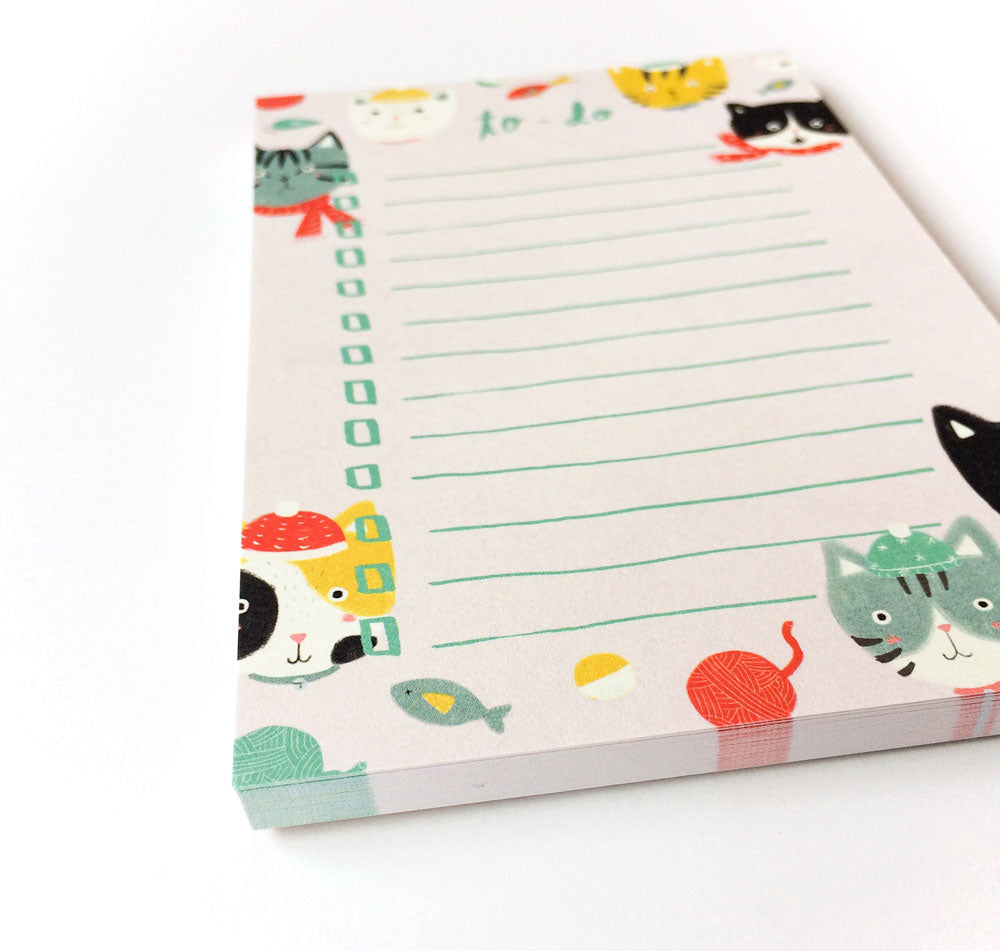 Colorful to-do list notepad featuring playful cat illustrations in winter attire, with lines for writing tasks and cute cat-themed decorations around the borders