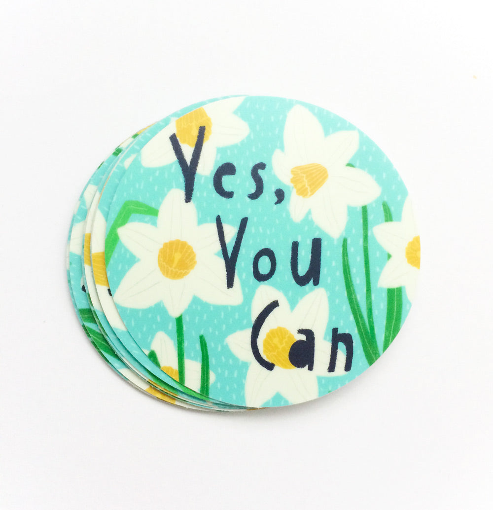 Round vinyl sticker with "Yes, You Can" text on a turquoise background with white flowers and yellow centers, inspiring confidence and positivity