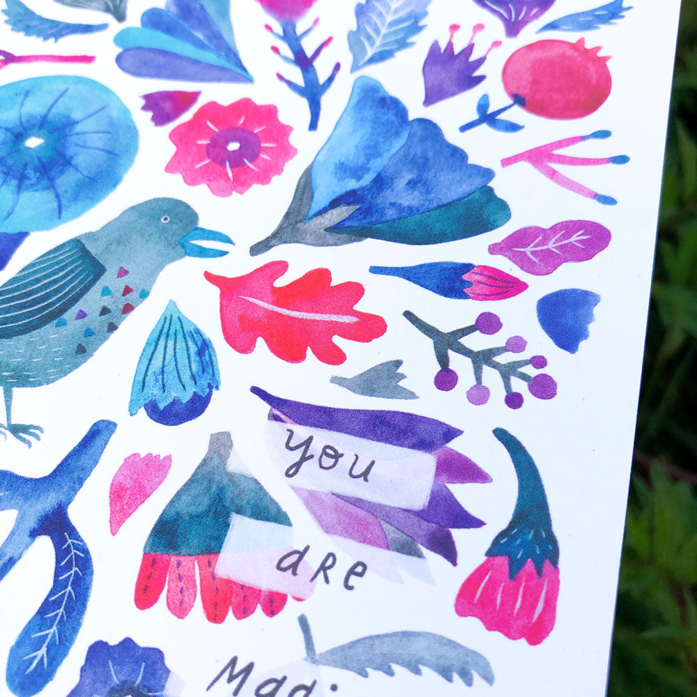 Whimsical watercolor greeting card featuring a colorful array of floral and nature-inspired elements, including a stylized bird, leaves, flowers, and a central banner with the handwritten text "You are Magic" in vibrant blue, pink, and purple hues.