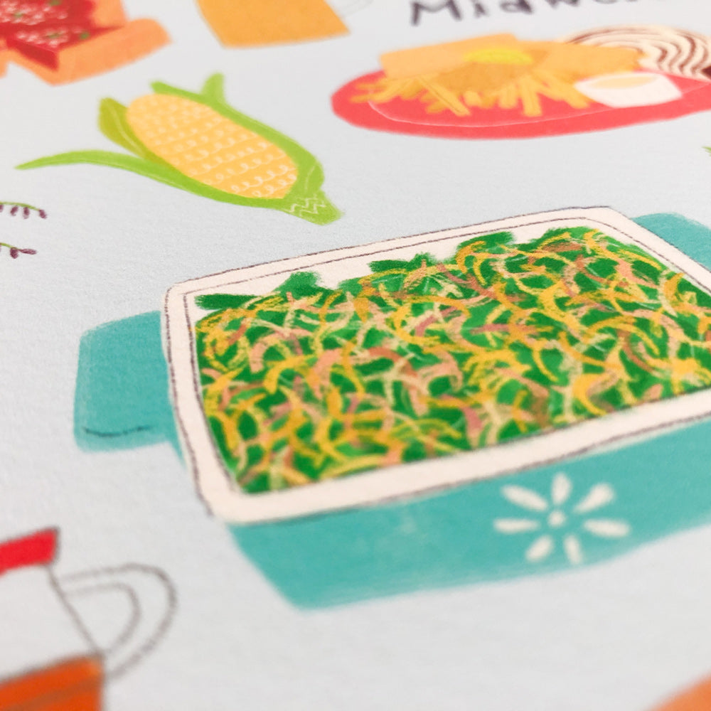 Close-up view of a colorful illustrated Midwest foods art print featuring a casserole dish, corn on the cob, and other regional food items on a textured paper background