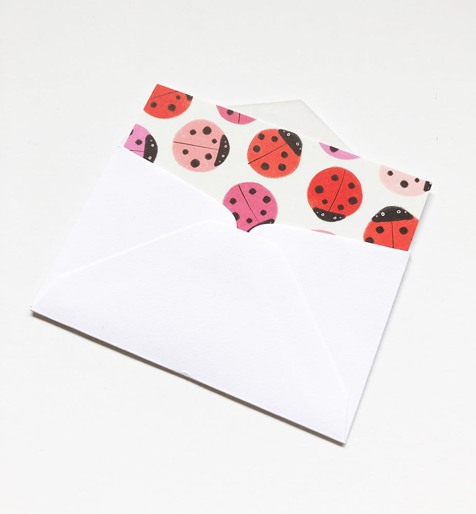 White envelope with colorful ladybug designs on the flap, showcasing red and pink ladybugs with black spots, perfect for tiny notes and gift enclosures