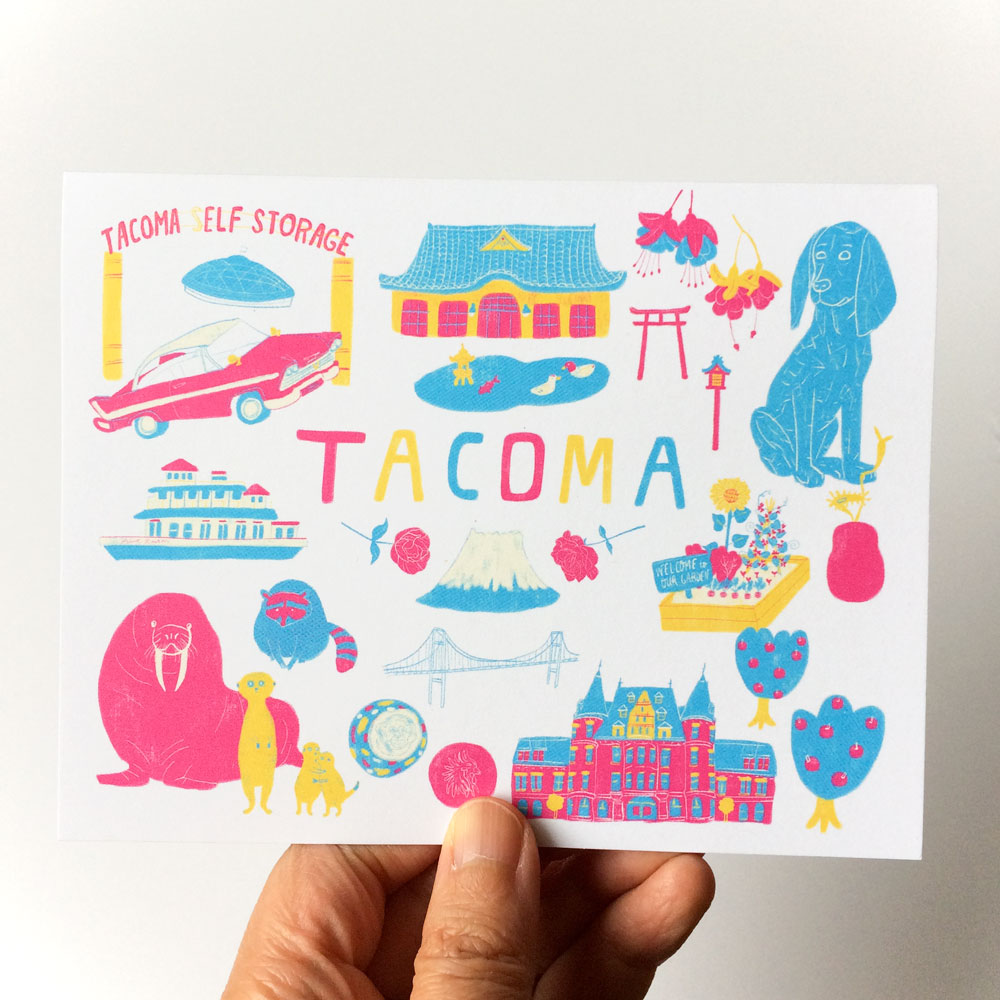 Colorful illustrated greeting card featuring iconic Tacoma landmarks and symbols, including the Tacoma Dome, Elf Storage sign, Narrows Bridge, and local wildlife, held in hand against white background.