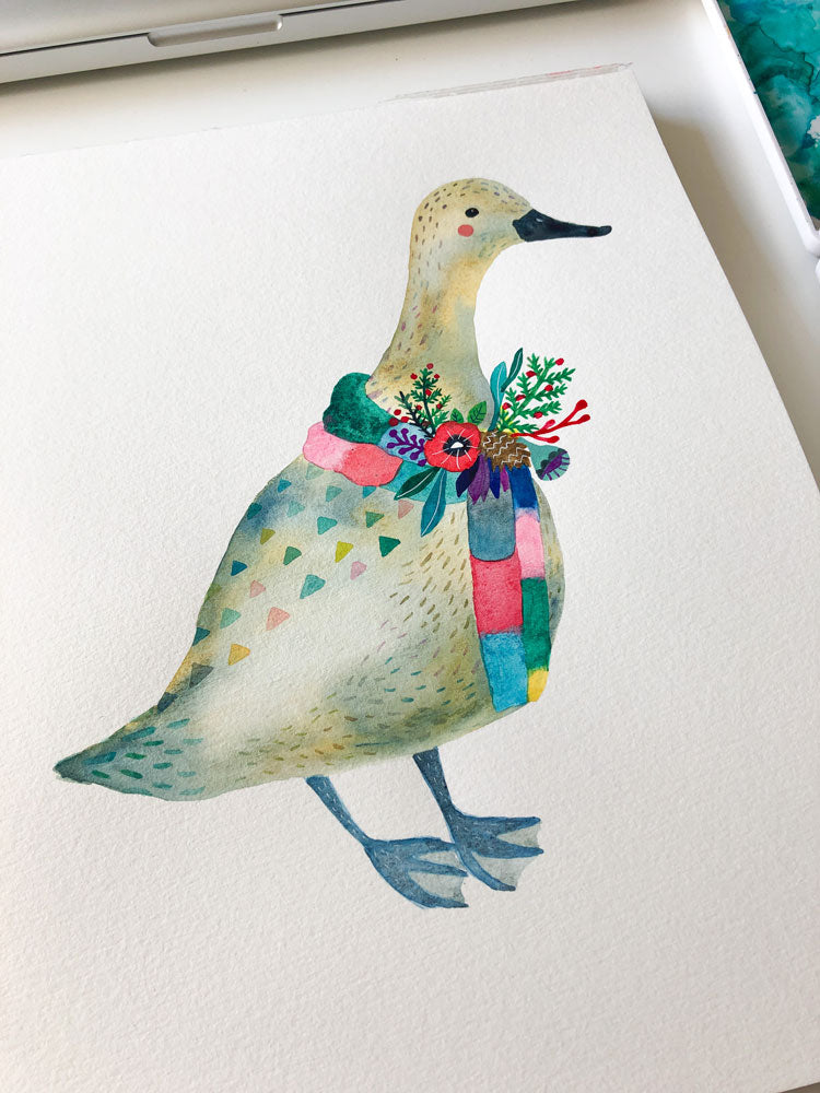 Watercolor illustration of a festive duck wearing a colorful scarf adorned with holiday flowers and foliage, standing on a white greeting card