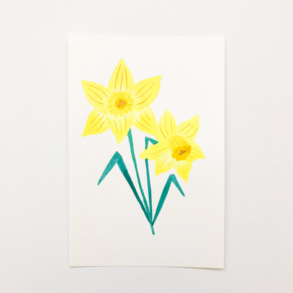 Watercolor painting of two bright yellow daffodils with green stems on white paper, showcasing simple yet elegant floral art in a 9x6 inch format