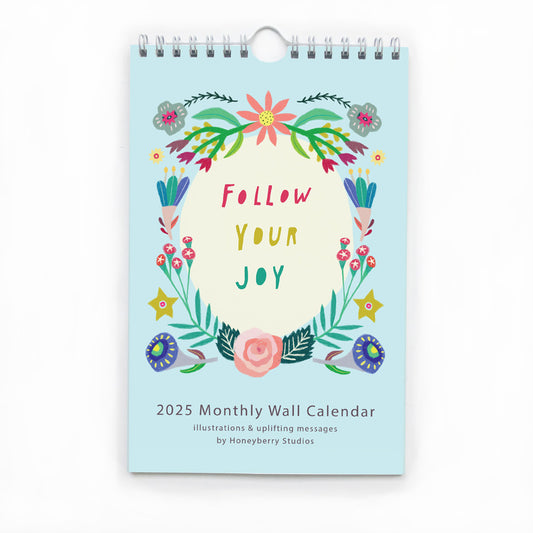 Colorful 2025 monthly wall calendar featuring floral design and "Follow Your Joy" message, with spiral binding and pastel blue cover