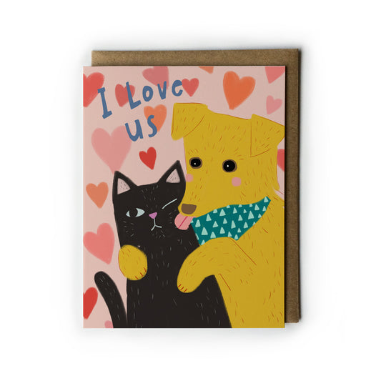 Greeting card with a black cat and a golden retriever hugging on a pink background with hearts, and 'I Love Us' text.